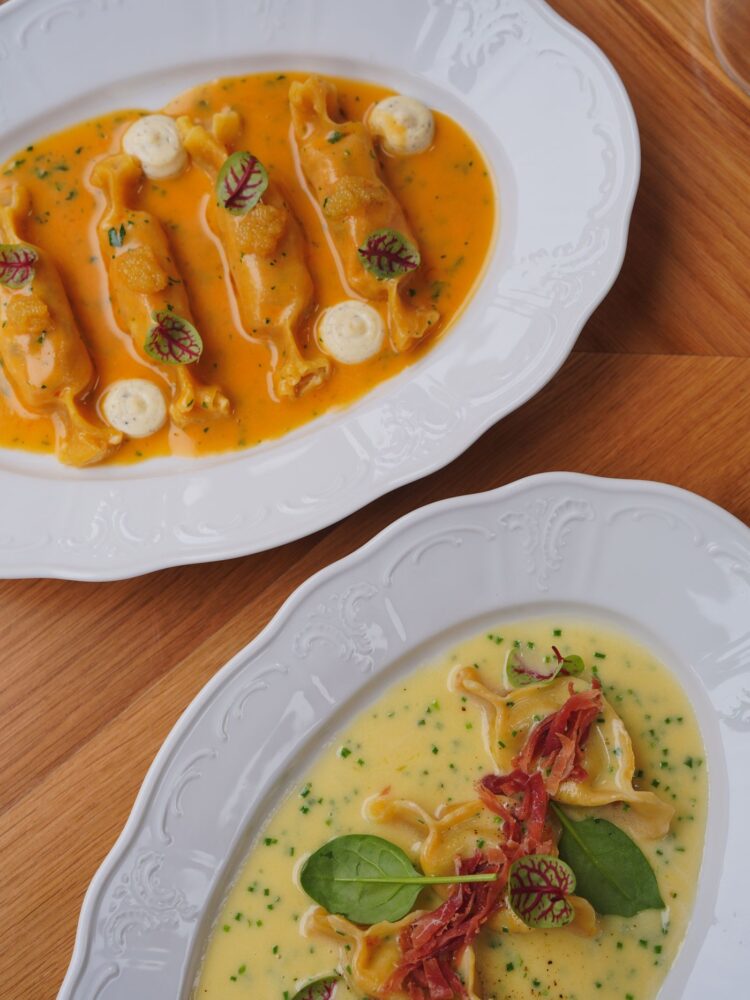 To pastaretter med sauce på et restaurantbord