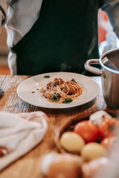 En kok tilbereder pasta ved et lyst køkkenbord
