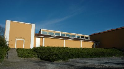 Willumsens Museums gule facade under en blå himmel i Frederikssund