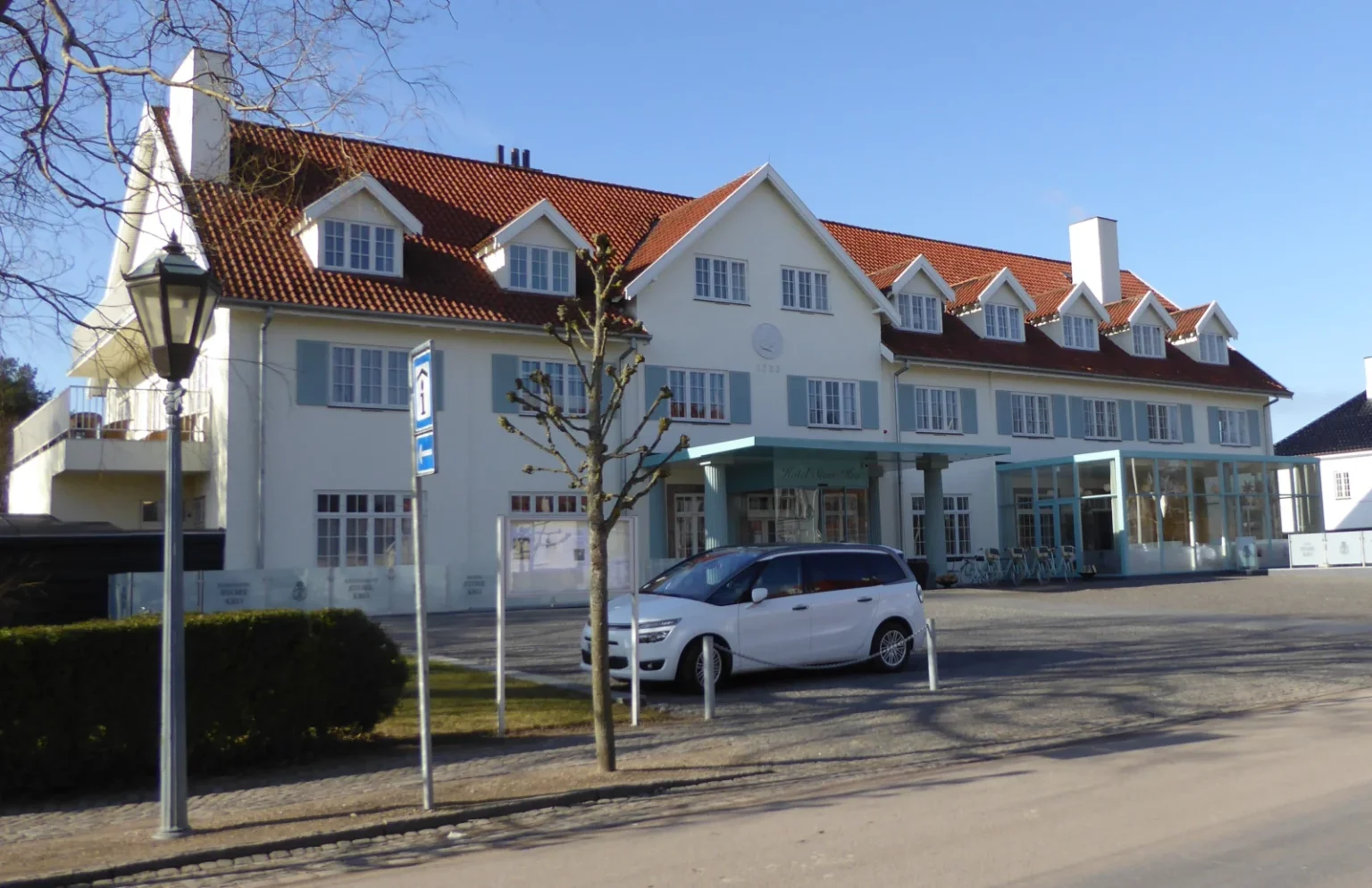 Fredensborg Store Kros lyse facade og røde tegltag i solskin