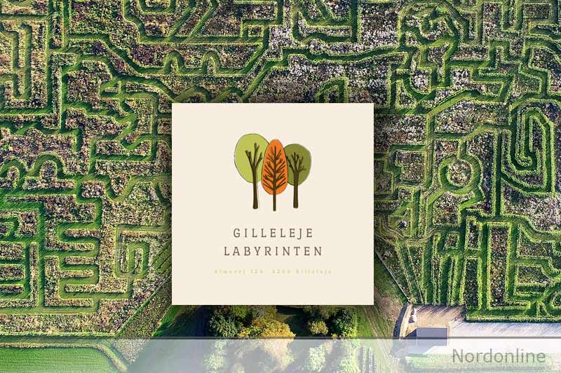 Gilleleje Labyrintens logo over et luftfoto af labyrintens grønne stier