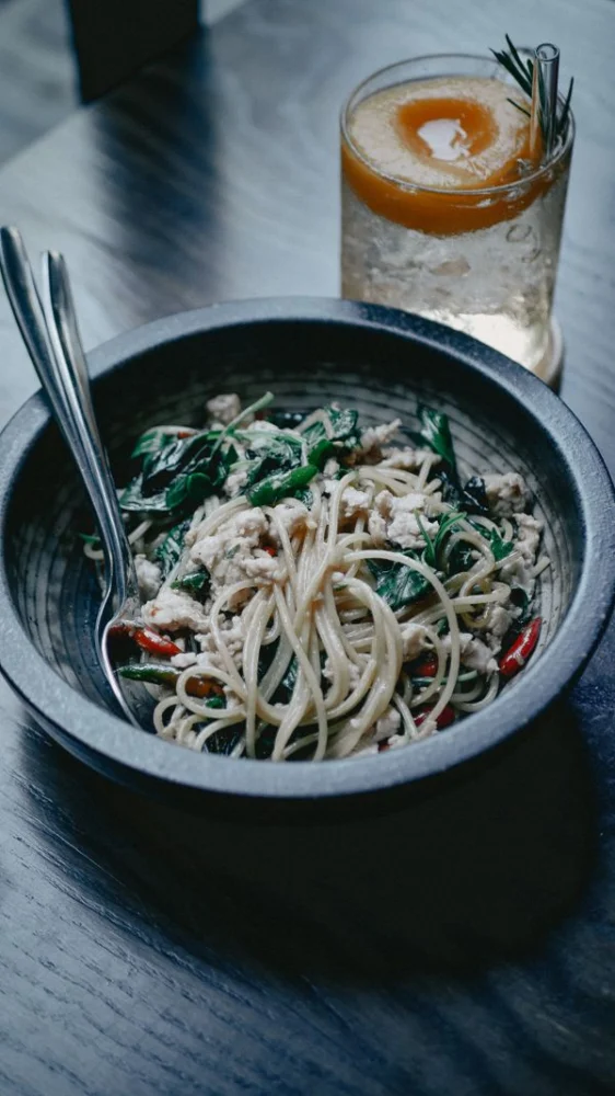 Pasta med friske grønne blade ved siden af en drink