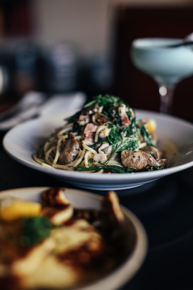 Spaghetti med cremet sauce, spinat og svampe på en tallerken