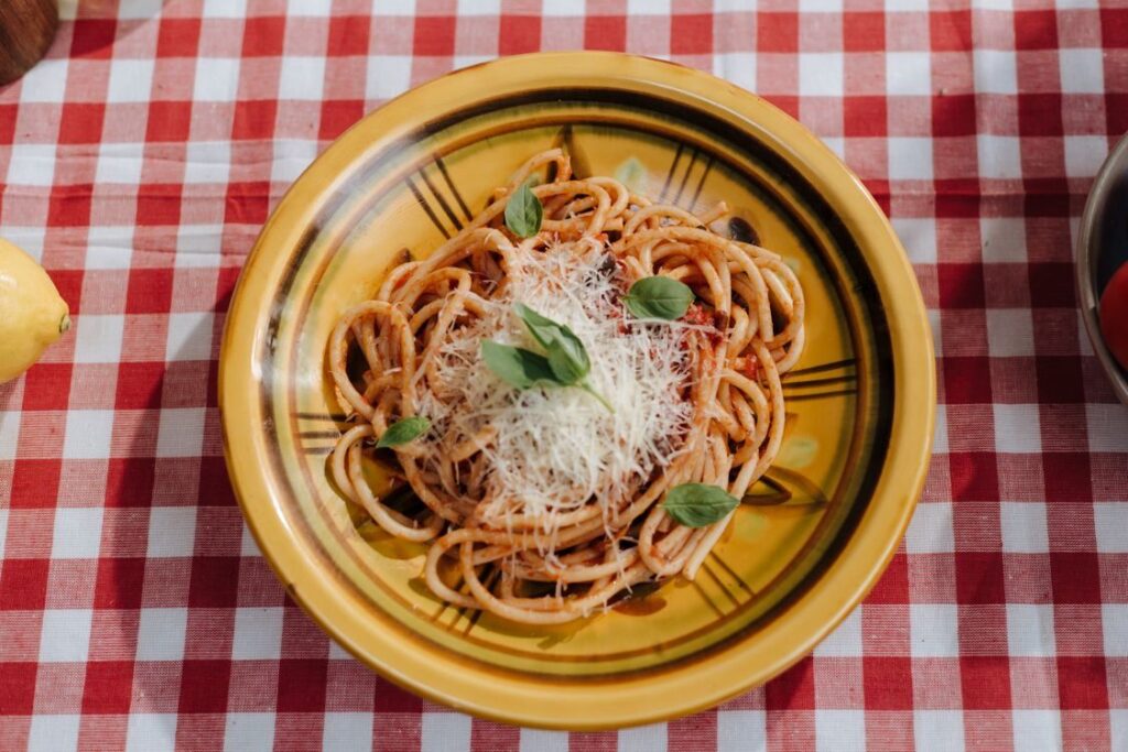 Pasta med tomatsauce, ost og basilikum på en ternet dug