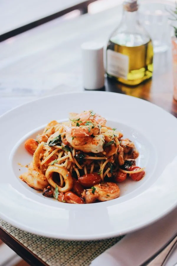 Pasta med sauce og garniture på en tallerken