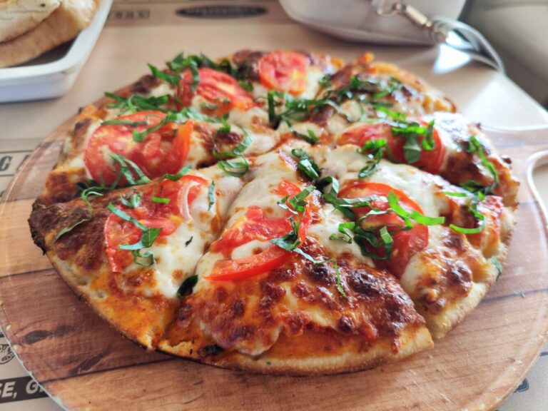 Margheritapizza med tomat, mozzarella og friske grønne blade