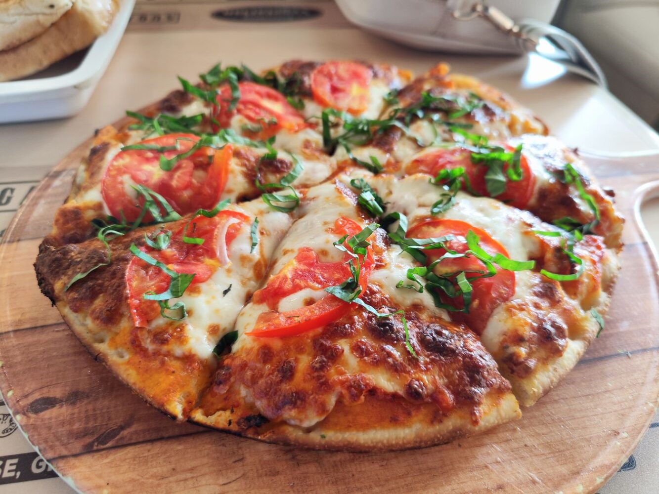 Margheritapizza med tomat, mozzarella og friske grønne blade
