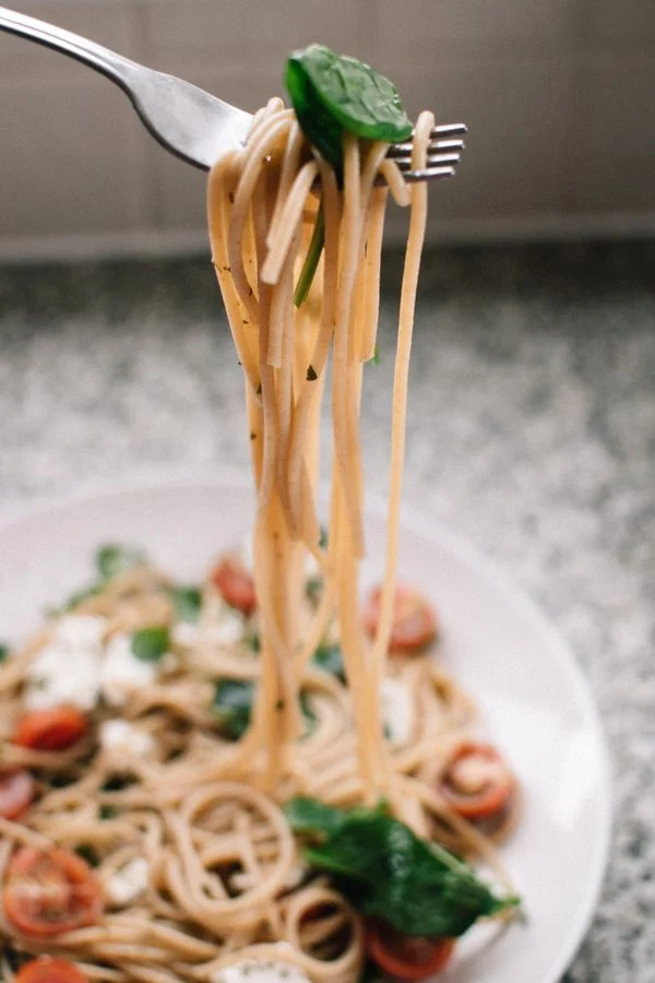 Pasta med sauce og garniture på en tallerken