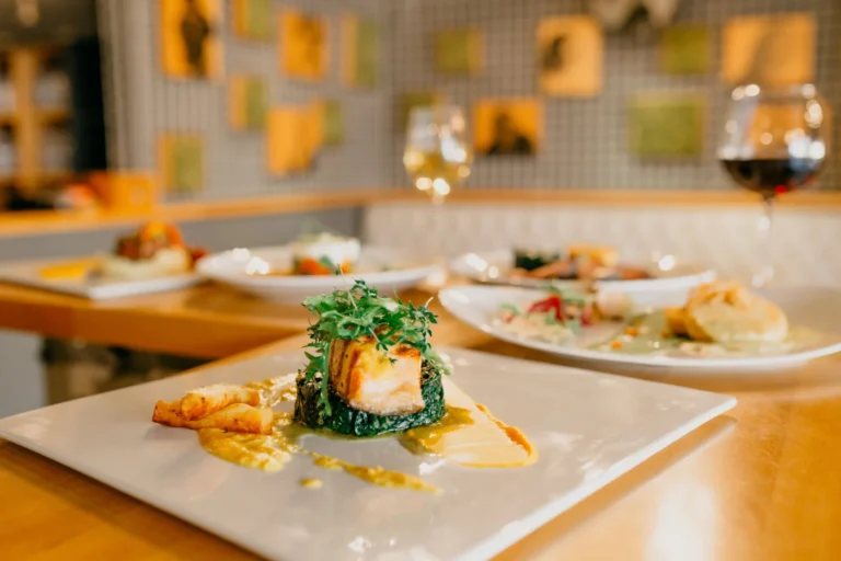 Anrettede retter og vinglas på et lyst restaurantbord